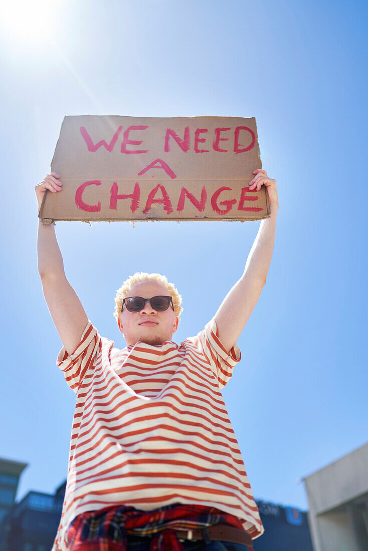 Young male protester holding change sign