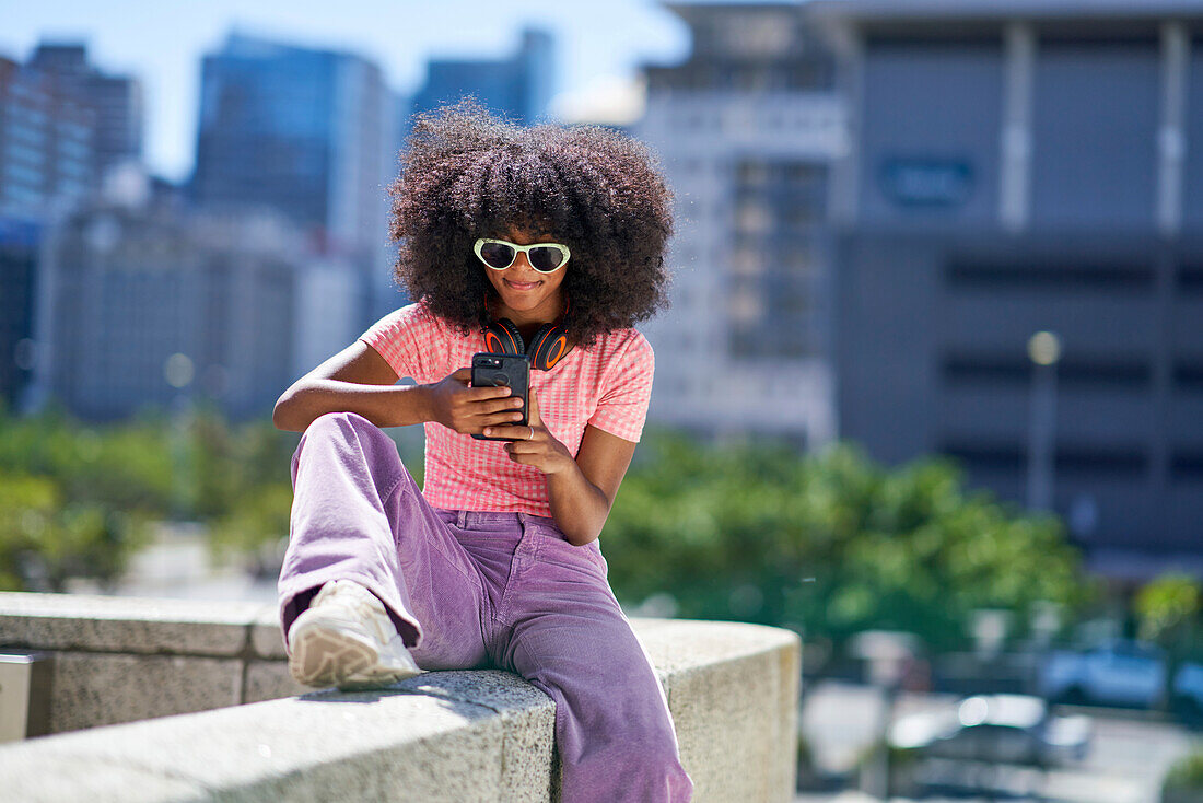 Young woman with headphones using smart phone