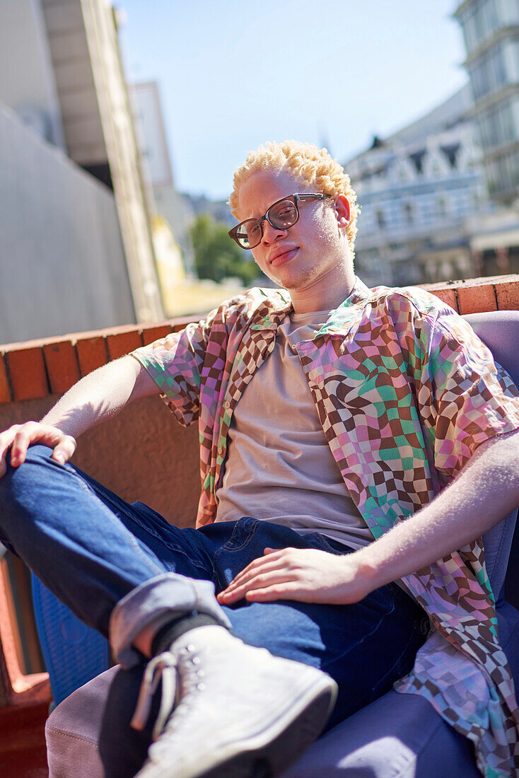 Young albino man on sunny rooftop