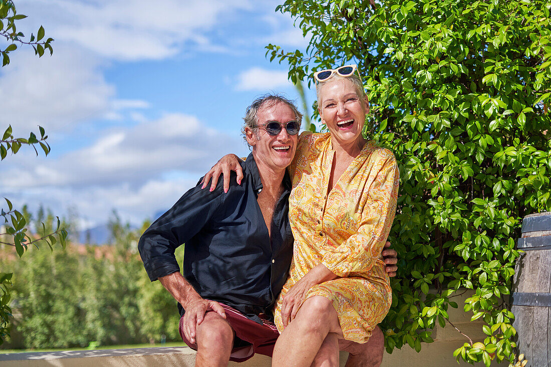 Senior couple laughing on sunny patio