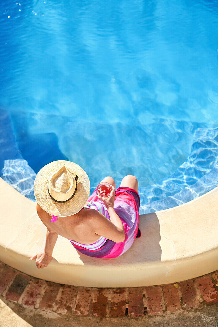 Senior woman relaxing by swimming pool