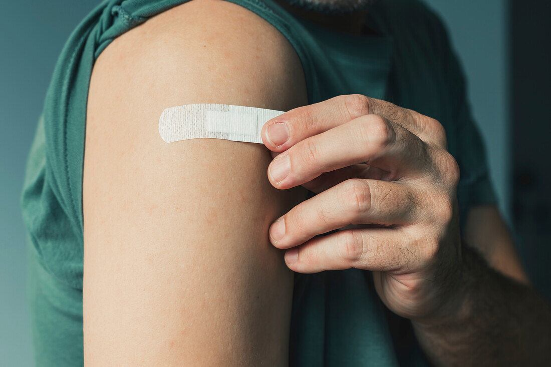 Person sticking plaster to arm