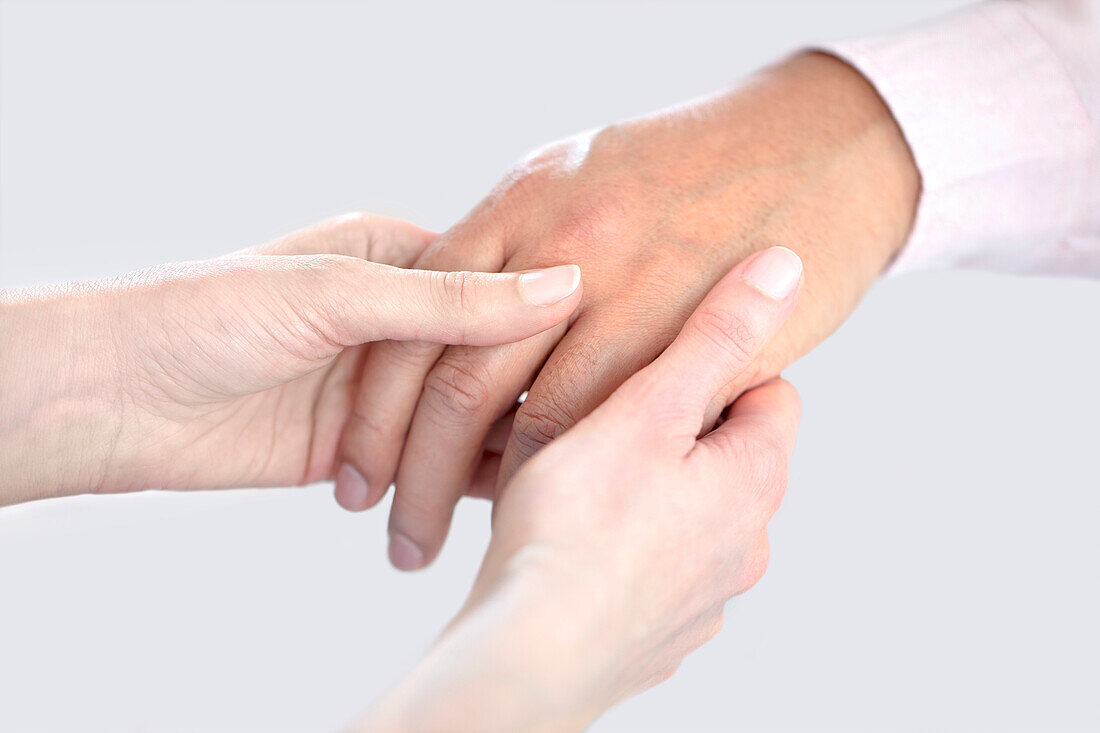 Doctor checking man's hand