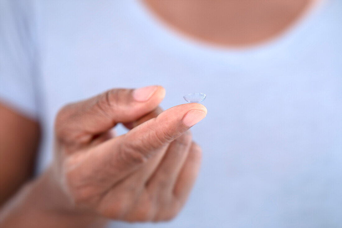 Contact lens on woman's finger
