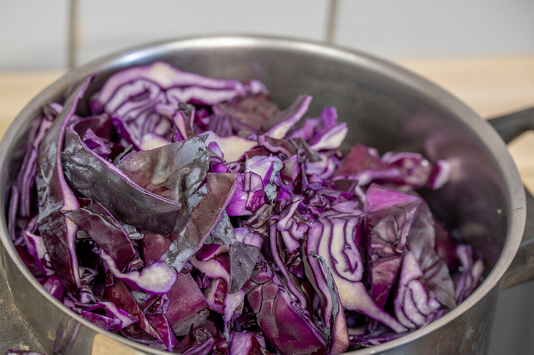 Raw red cabbage in cooking pot, boiling down