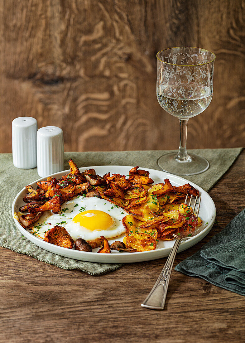 Fried potatoes with fried egg and wild mushrooms