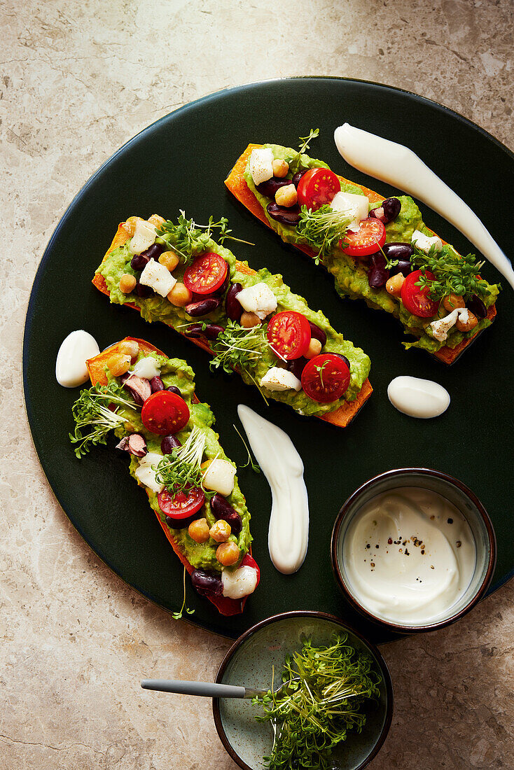 Sweet potato slices from the oven with guacamole and yoghurt sauce