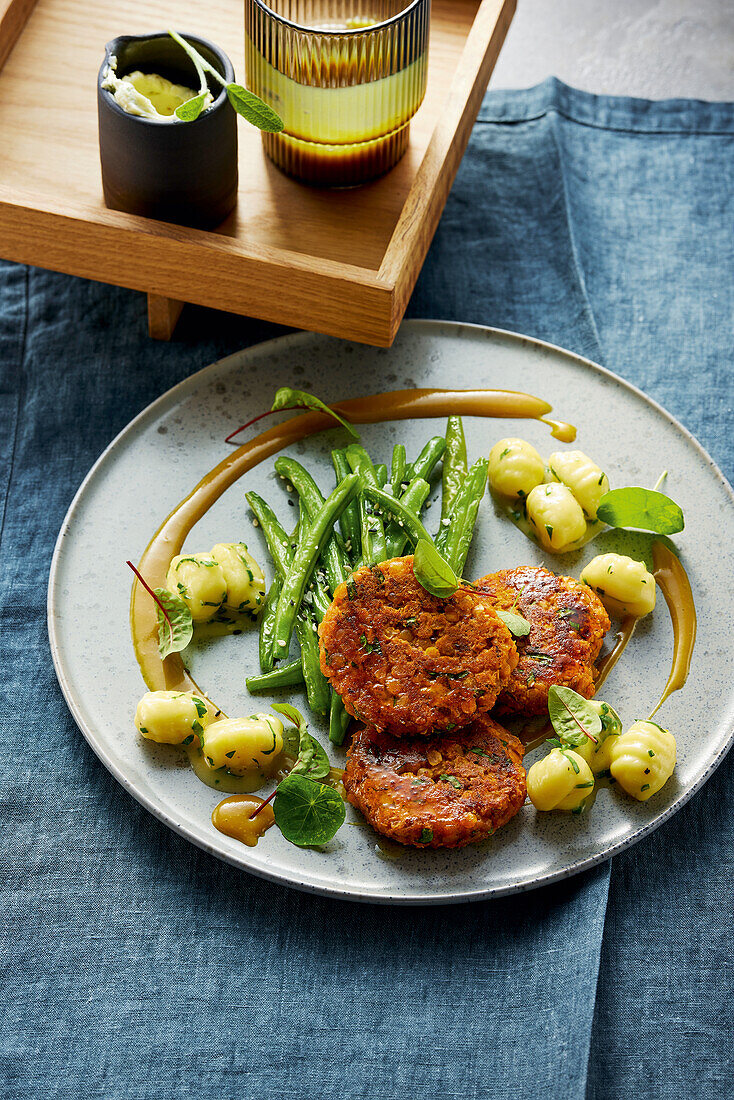 Linsenpuffer mit Gnocchi, frittierten grünen Bohnen und Senfdip