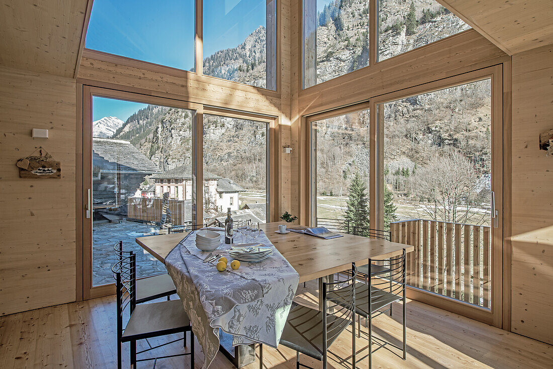 Essbereich mit Holzverkleidung und Panoramafenstern in Chalet