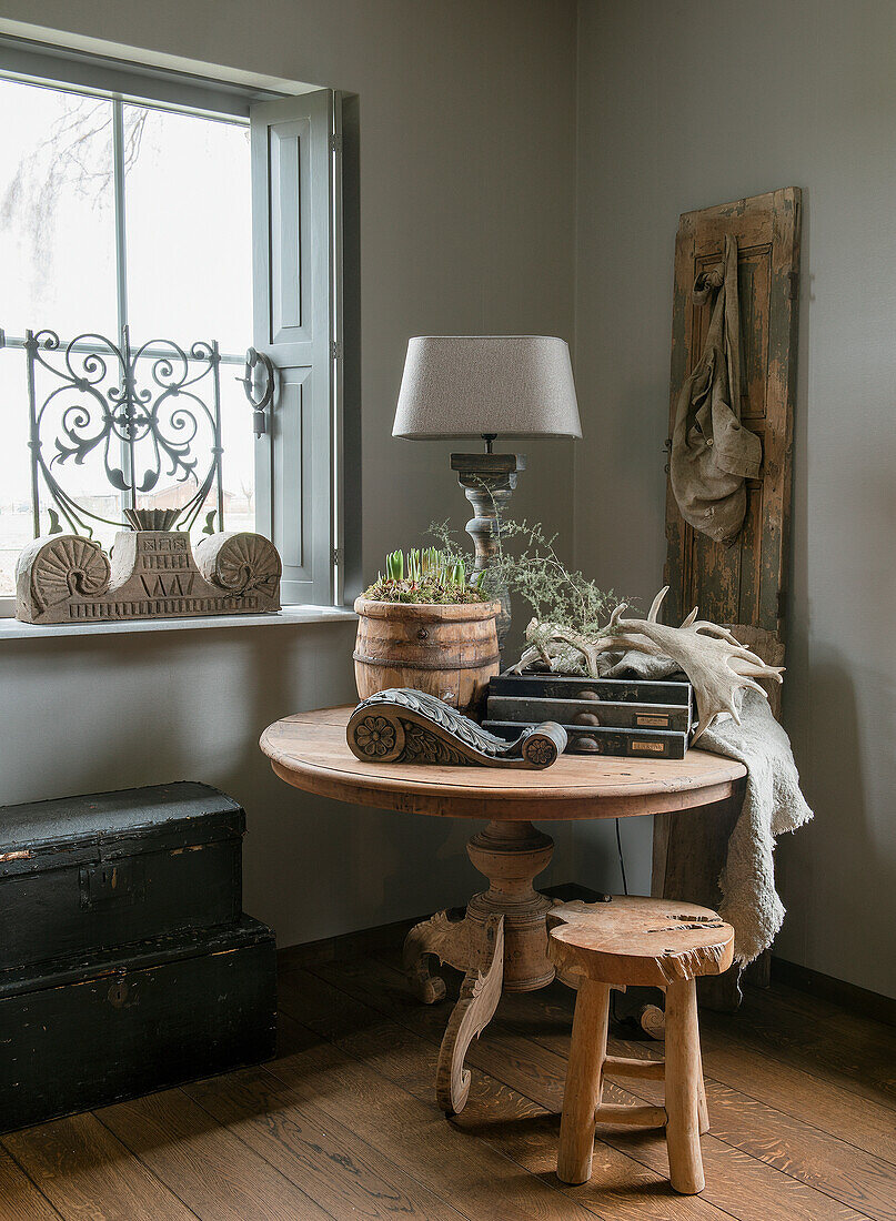 Kleiner runder Holztisch mit rustikaler Dekoration und Hocker in Landhausstil-Ecke