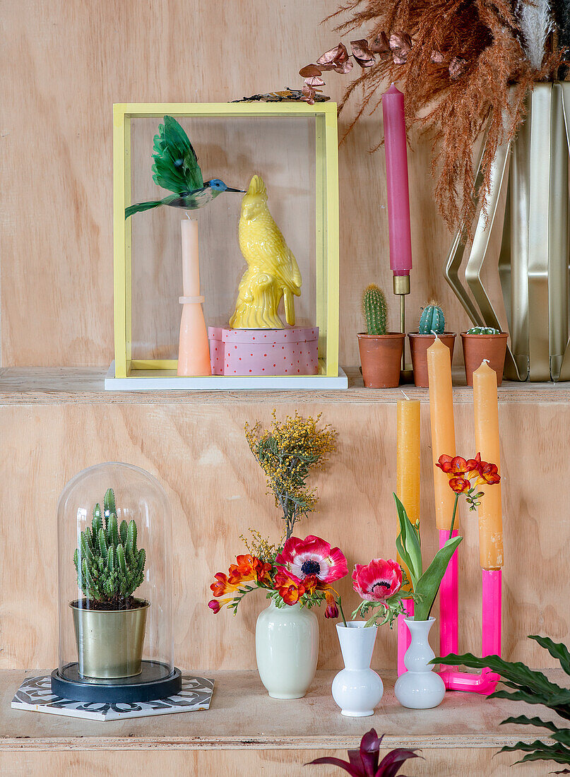 Decorated shelf with plants, candlesticks and various decorative objects