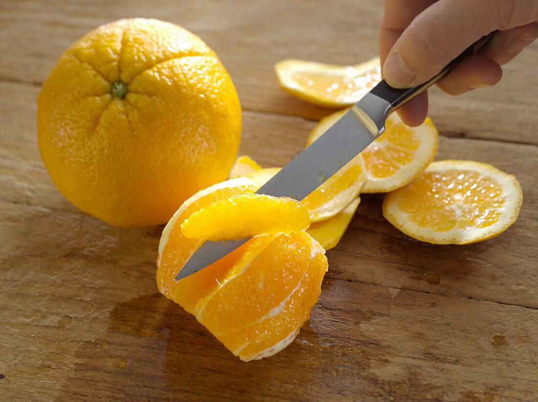 An orange being filleted