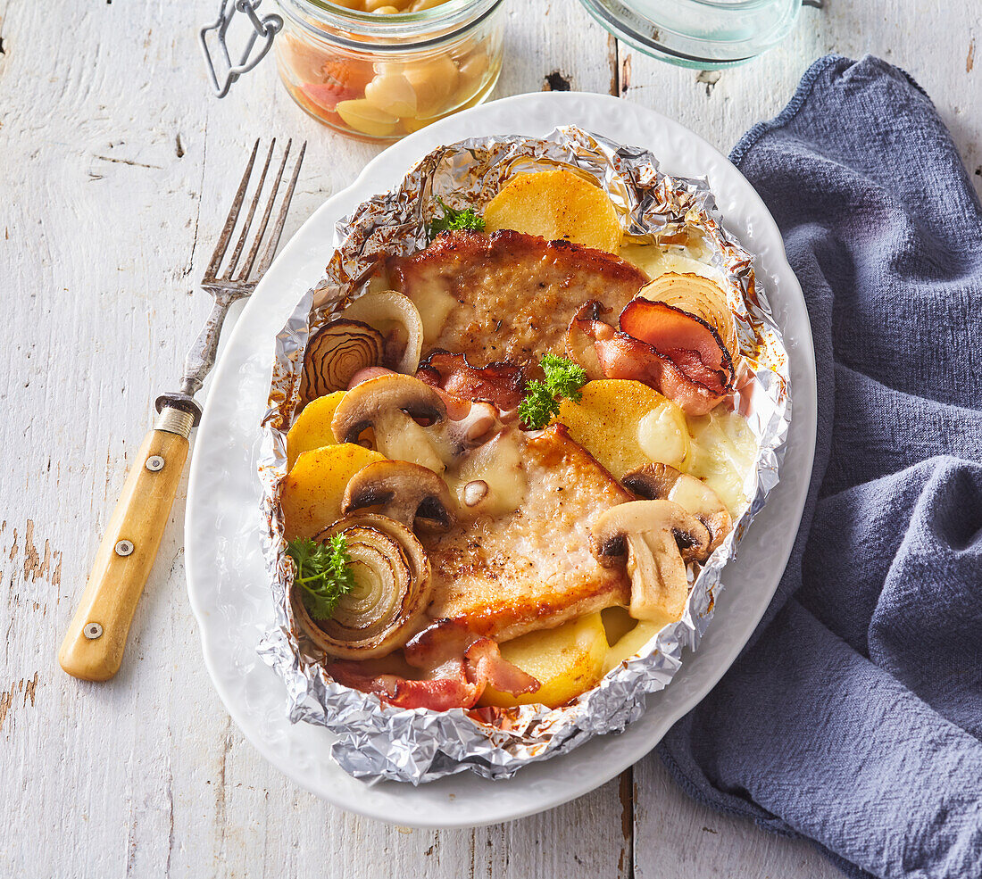 Schweinekoteletts mit Kartoffeln, Pilzen und Speck aus der Alufolie