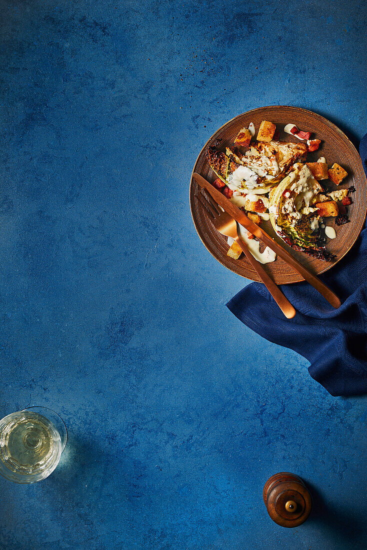 Grilled savoy cabbage with Caesar dressing and bacon croutons