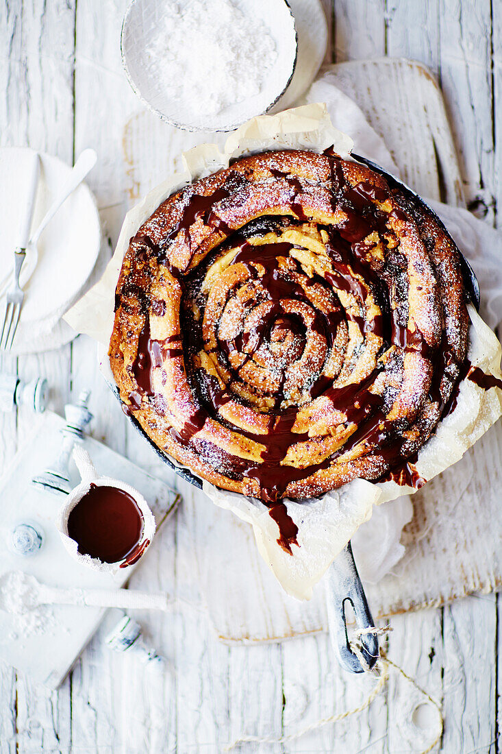 Giant skillet chocolate and cinnamon spiral with chocolate sauce and vanilla ice-cream