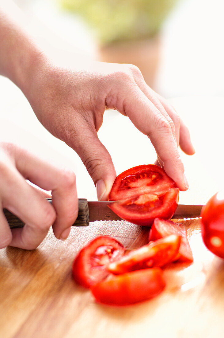 Hände schneiden Tomaten