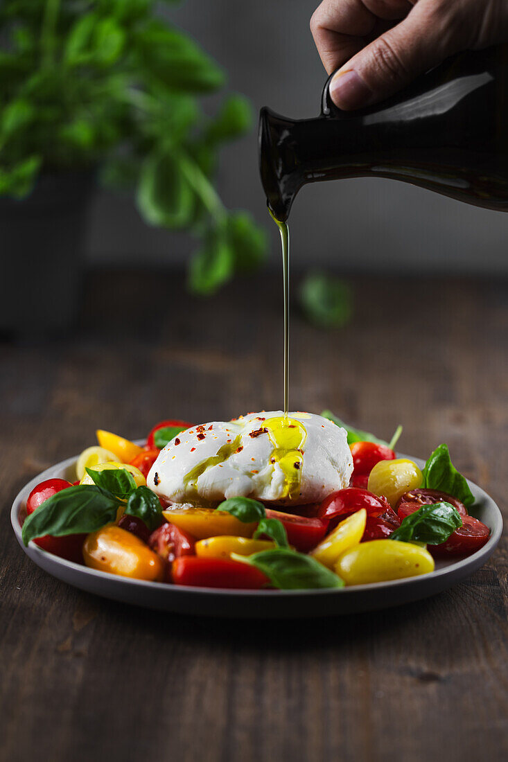 Salat Caprese mit Olivenöl beträufeln