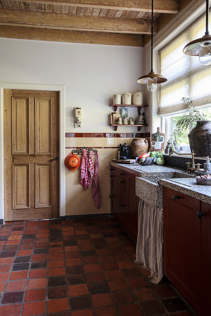 Rustic kitchen with patterned tiles and wooden beamed ceiling