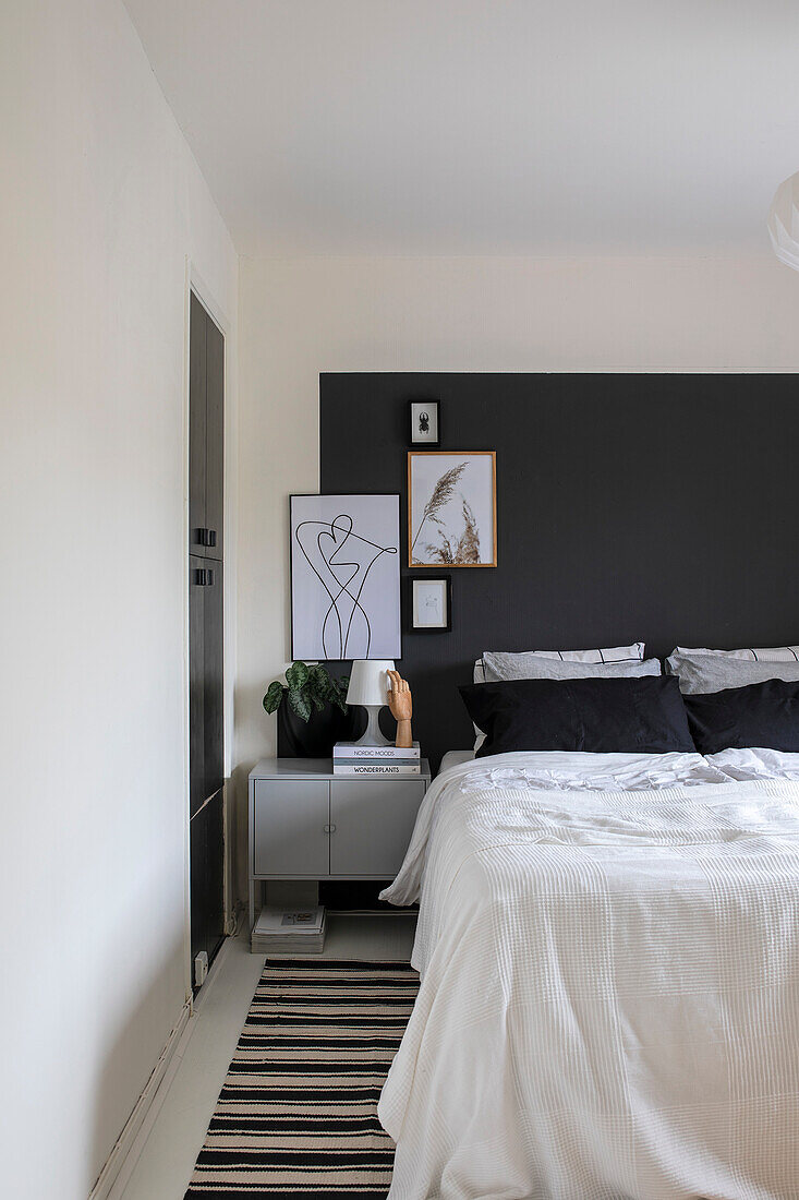 Modern bedroom with black and white accents and framed art on the wall