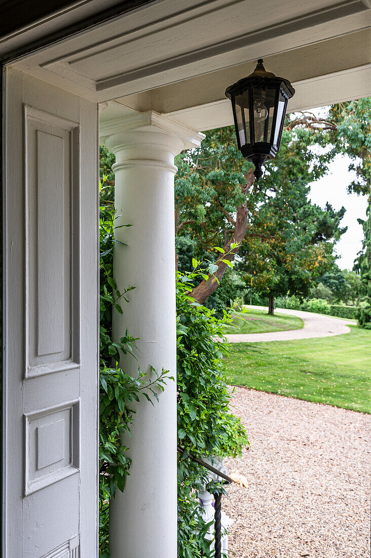 Entrance area of a house with a lantern and a view of the garden