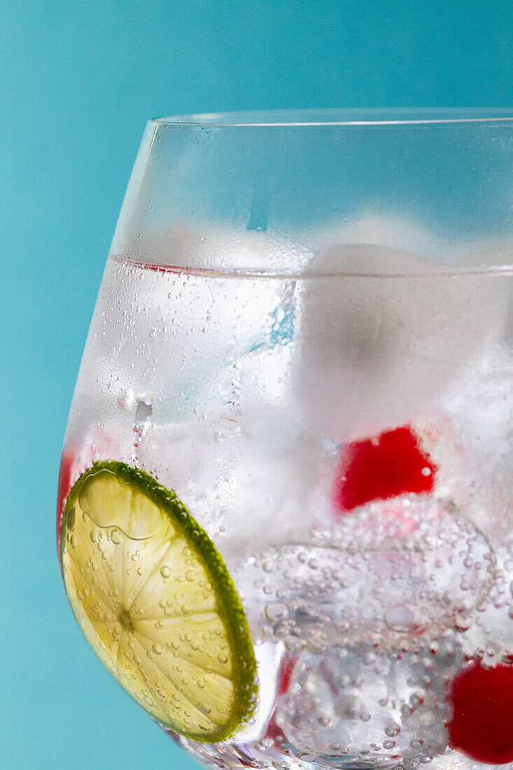 Mineral water cocktail with ice cubes and a slice of lime