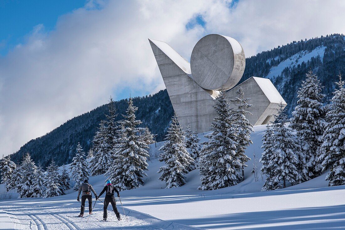 France,Haute Savoie,Bornes massif,Plateau des Glieres,skating skiers on cross country ski trails and the national monument of the resistance of Emile Gilioli