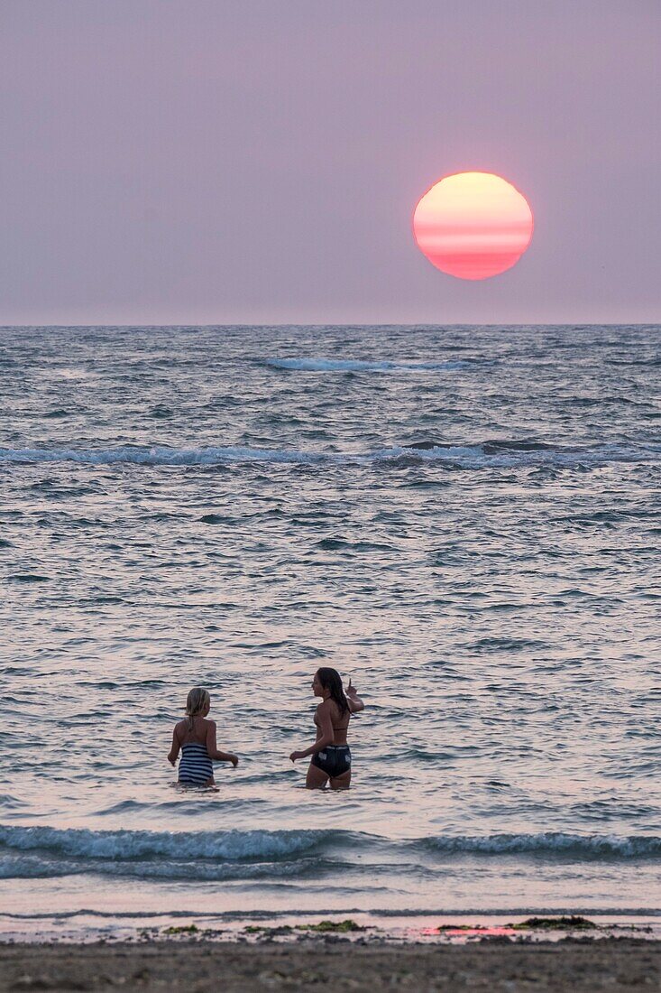 Frankreich,Charente Maritime,Insel Oleron,junge Frauen am Strand bei Sonnenuntergang