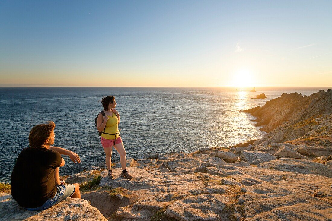 Frankreich,Finistere,Plogoff,Wanderer bei Sonnenuntergang an der Pointe du Raz