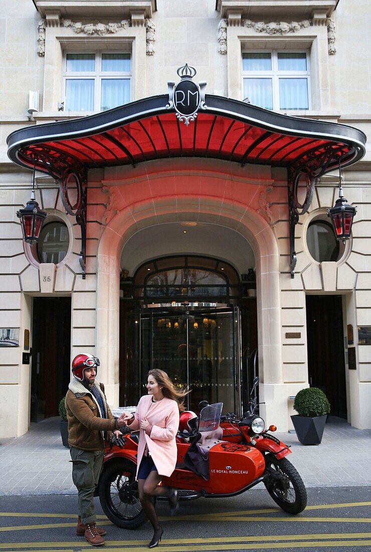 Frankreich,Paris,Royal Monceau Hotel,Frau fährt in einem Retro-Seitenwagen vor der Hotelfassade, bewacht von zwei Dienern