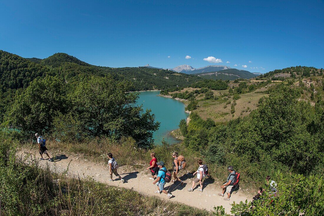 France,Isere,Trieves,Monteynard lake,group of hikers on the path of the footbridges