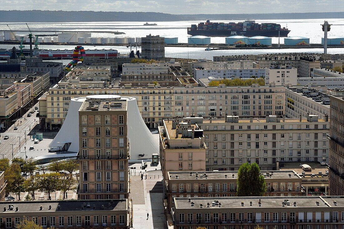 Frankreich,Seine Maritime,Le Havre,Von Auguste Perret wiederaufgebautes Stadtzentrum,von der UNESCO zum Weltkulturerbe erklärt,Perret-Gebäude um das von Oscar Niemeyer geschaffene Kulturzentrum Vulkan,im Hintergrund verlässt ein Containerschiff den Handelshafen