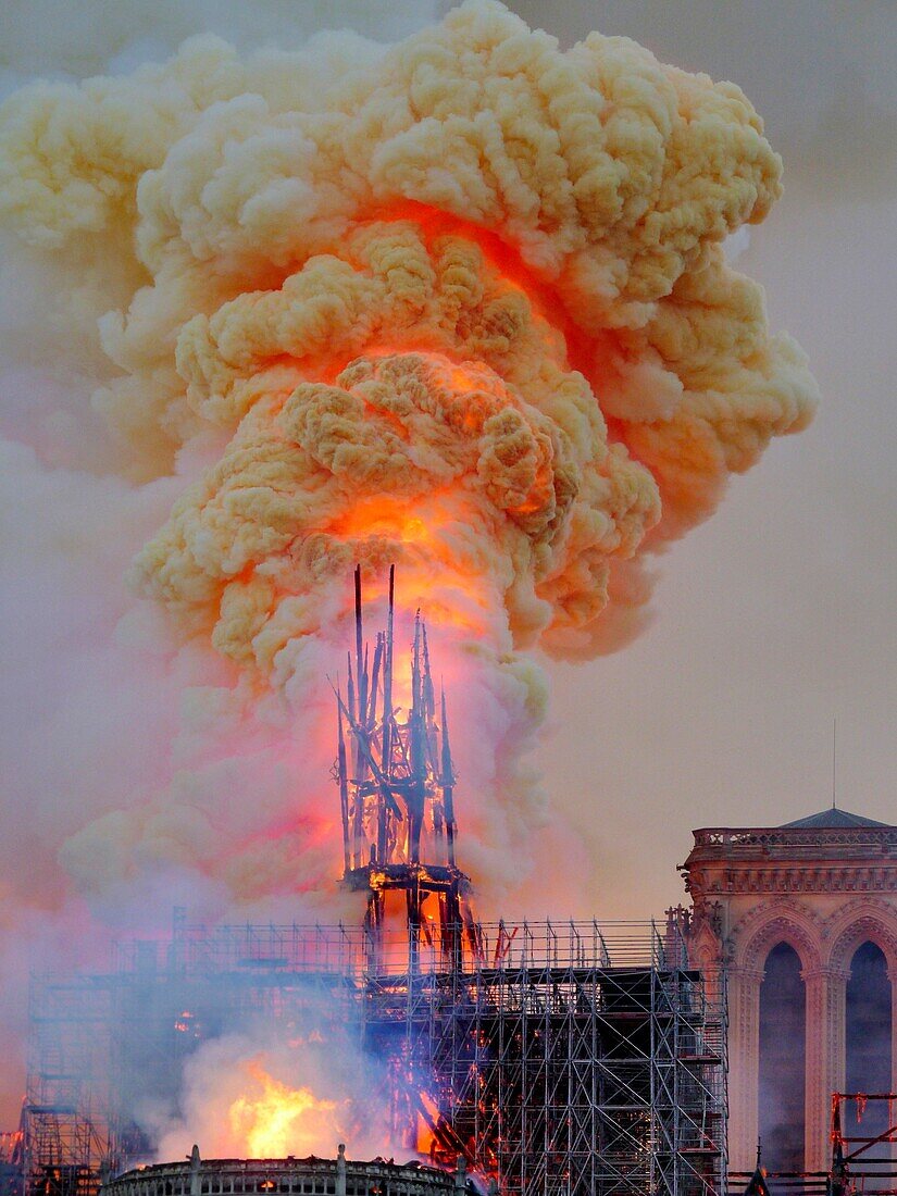 [ Unpublished - Exclusive ] France,Paris,area listed as World Heritage by UNESCO,Notre Dame Cathedral of 14th century Gothic architecture during the fire of 15th April 2019,close-up of the fall of the arrow in thick yellow smoke from burning the lead roof