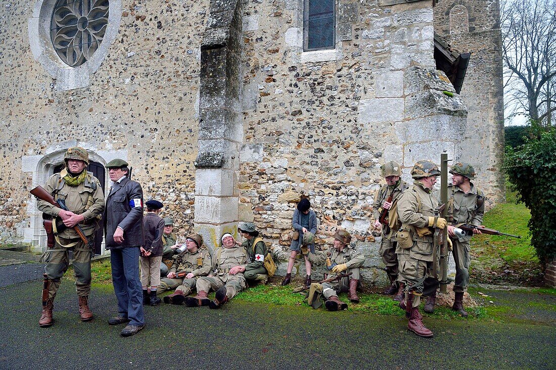 Frankreich,Eure,Chambray,Allied Reconstitution Group (Verein zur historischen Rekonstruktion des 2. Weltkriegs und des französischen Maquis),Reenactors in Uniform der 101. US-Luftlandedivision und Partisanen der französischen Streitkräfte des Innern (FFI) bei einer Rast vor der Kirche