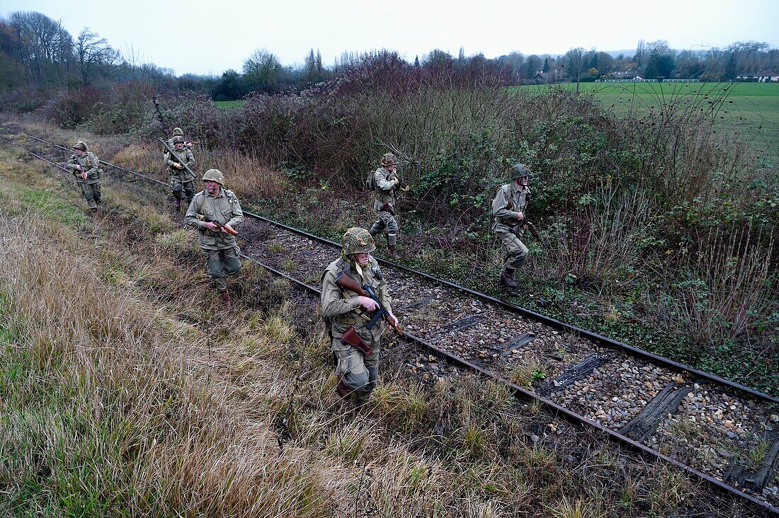 Frankreich,Eure,Cocherel,Allied Reconstitution Group (US World War 2 and french Maquis historical reconstruction Association),Reenactors in Uniform der 101st US Airborne Division, die sich entlang einer Eisenbahnstrecke bewegen