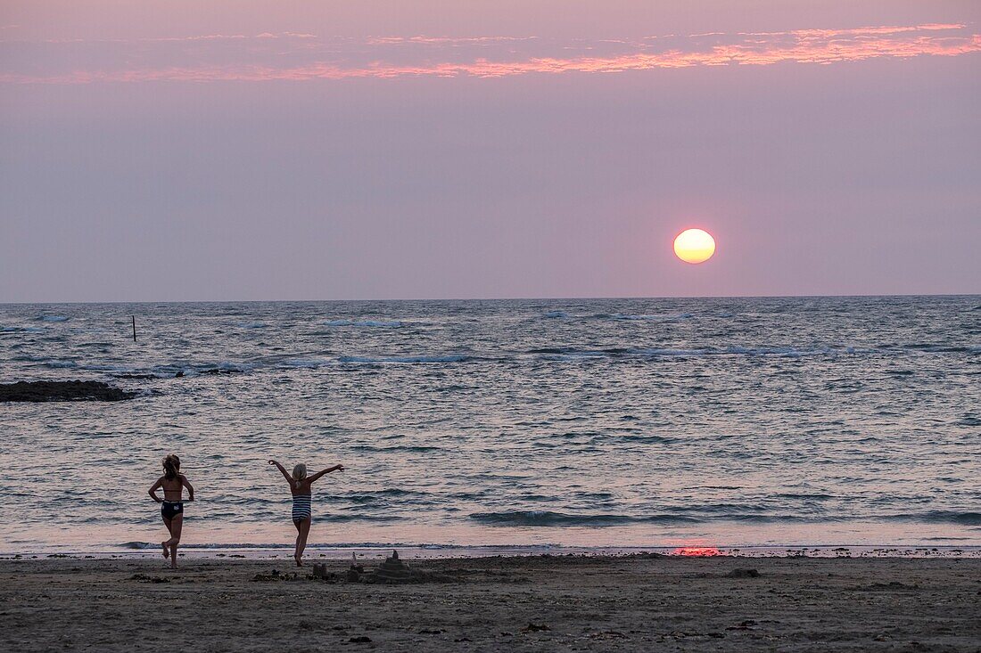 Frankreich,Charente Maritime,Oleron Insel,junge Frauen am Strand bei Sonnenuntergang