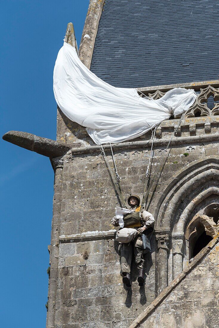 France,Manche,Cotentin,Sainte Mere Eglise,one of the first communes of France liberated on June 6,1944,model of American paratrooper John Steele (1912-1969) from the 505th Parachute Infantry Regiment who landed on the bell tower of the church