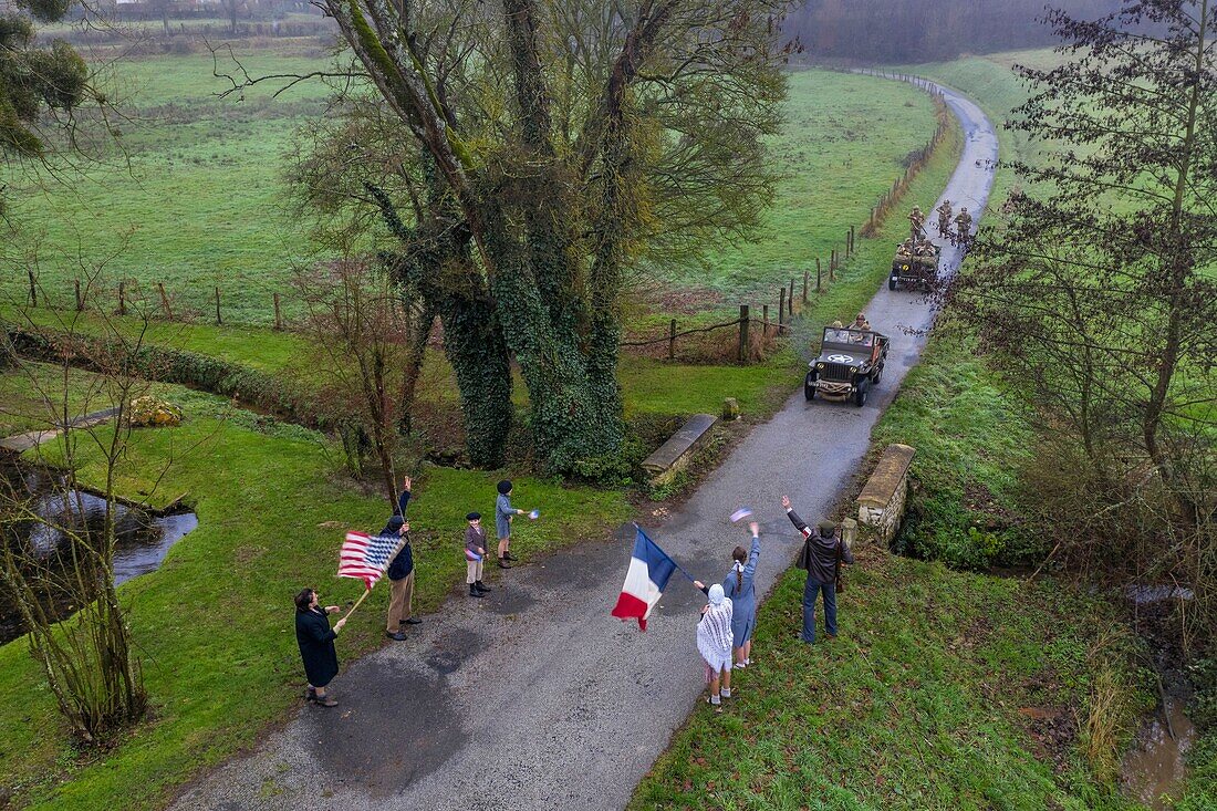 France,Eure,Sainte Colombe prés Vernon,Allied Reconstitution Group (US World War 2 and french Maquis historical reconstruction Association),reenactors in uniform of the 101st US Airborne Division progressing in a jeep Willys welcomed as liberators by villagers and FFI (aerial view)