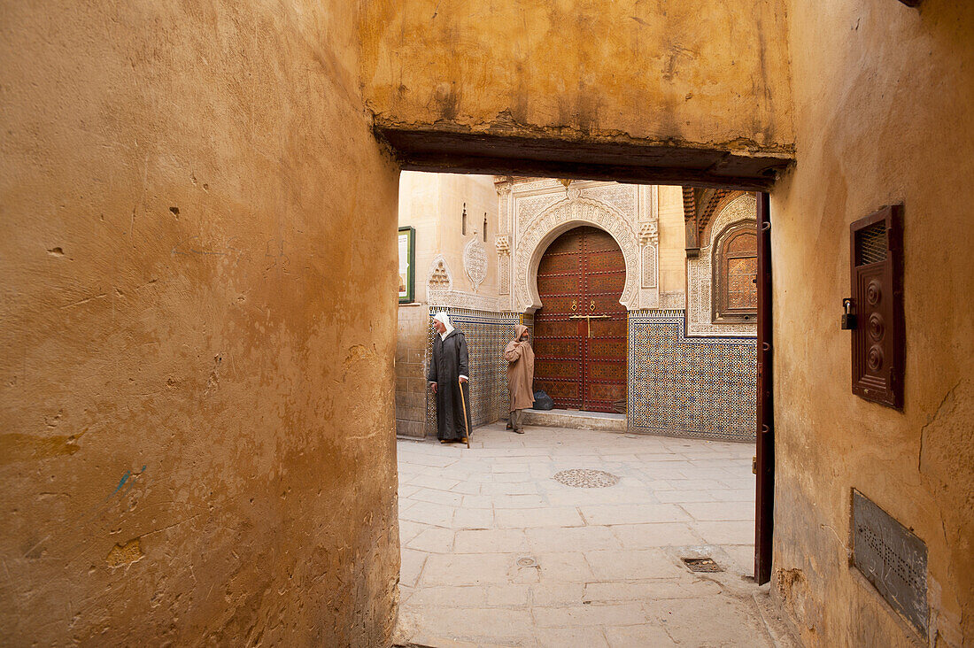 Morocco,Two men outside entrance to Sidi Tijani Mosque,Fez