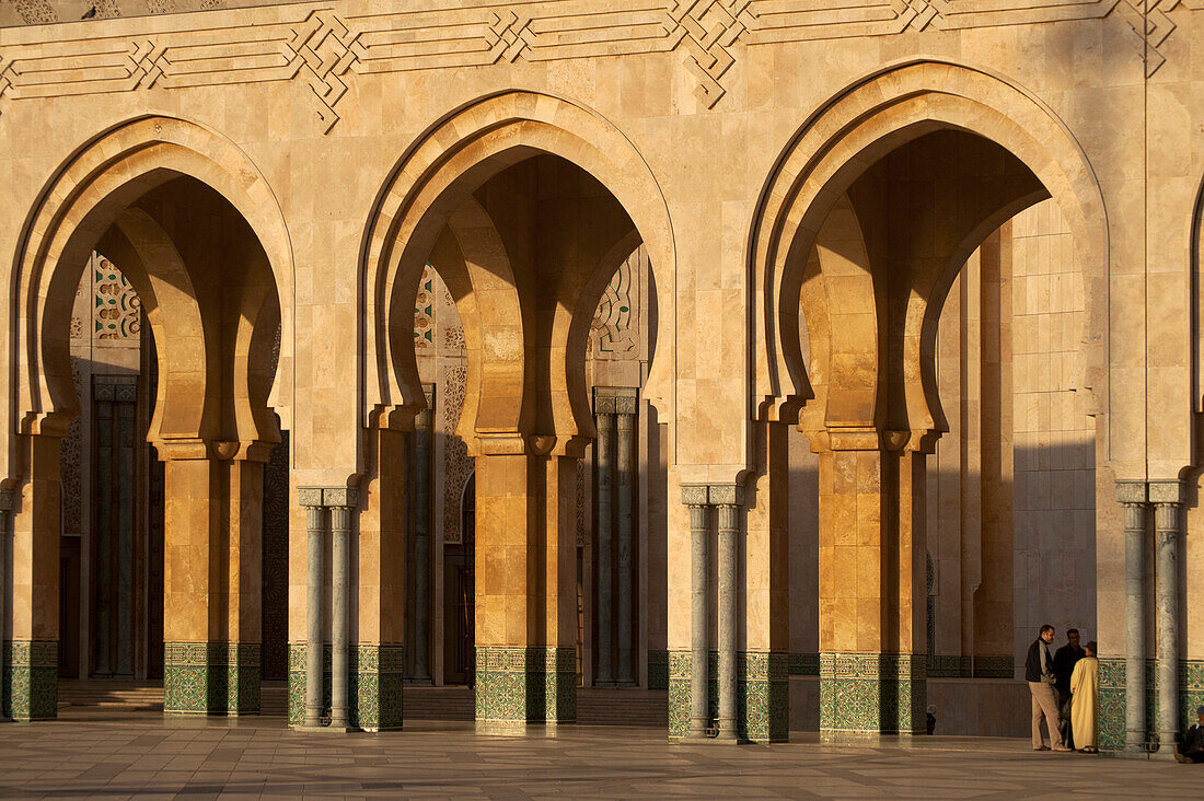 Marokko,Männer plaudern neben der Hassan II Moschee,Casablanca