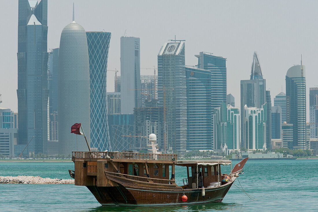 Qatar,Wooden boat in front of modern city skyline,Doha