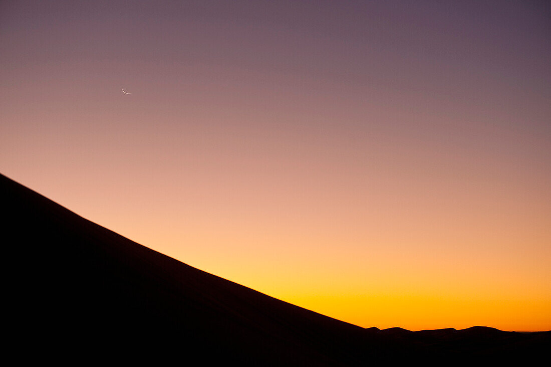 Marokko,Mondsichel über Sanddüne in der Abenddämmerung bei Merzouga in der Sahara-Wüste,Erg Chebbi-Gebiet