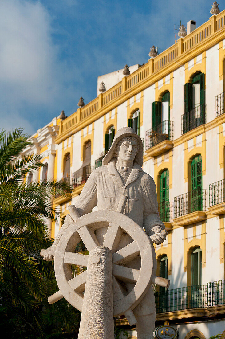 Spain,Ibiza,Statue of sailor at helm in front of old residential building,Ibiza Town