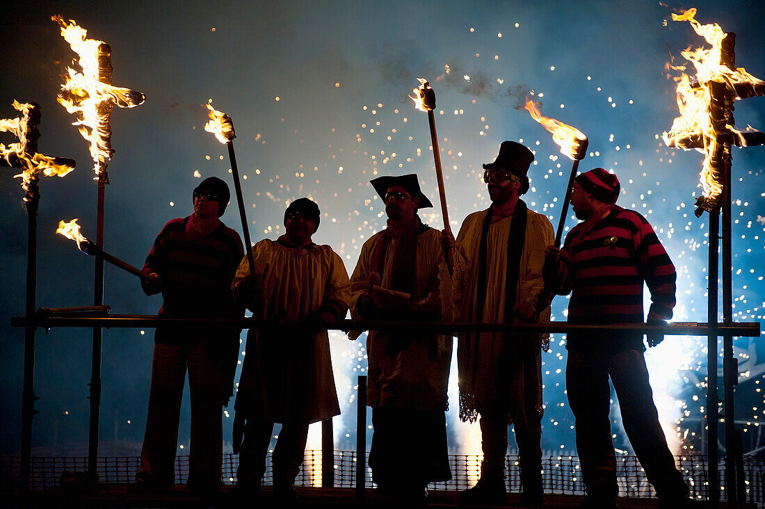 UK,England,Menschen als Geistliche gekleidet auf einem Stand mit Feuerwerk hinter ihnen bei der Newick bonfire night, East Sussex