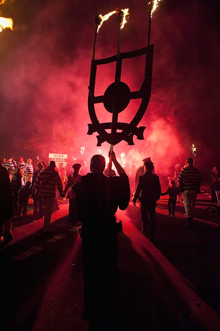 UK,England,East Sussex,Mann mit Banner als Mönch gekleidet von der Southover Bonfire Society geht in der Prozession der Nevill Junior Bonfire night,Lewes