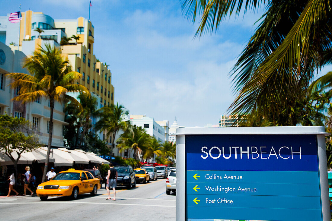 USA.,Florida,Miami,Ocean Drive,South Beach,Bright yellow taxi passing South Beach sign