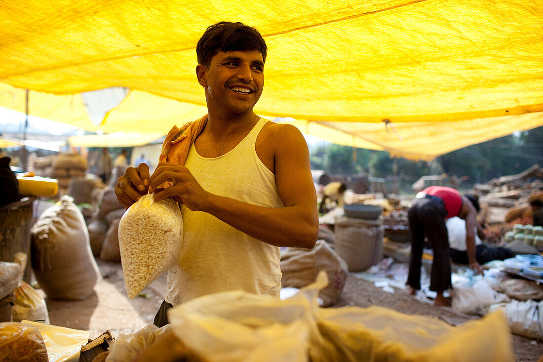 Vendor bags produce,Chaudi Market,Chaudi,Goa,India.