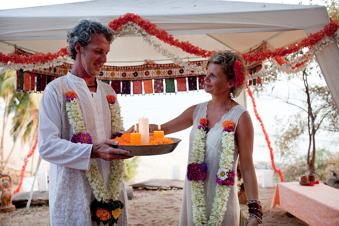 Ein westliches Paar hat eine spirituelle Hochzeitszeremonie im Harmonic Healing Centre, Patnum, Goa, Indien.