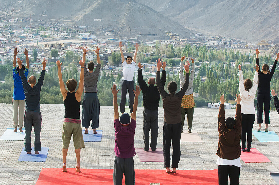 Yoga 'salutation to the sun' performed in front of the Shanti (Peace) Stupa overlooking Leh. Ladakh,Province of Jammu and Kashmir,India