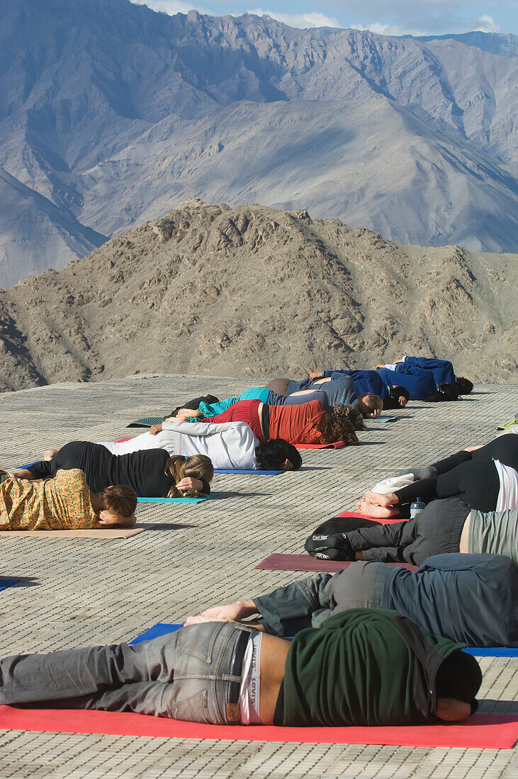 Yoga 'salutation to the sun' performed in front of the Shanti (Peace) Stupa overlooking Leh. Ladakh,Province of Jammu and Kashmir,India