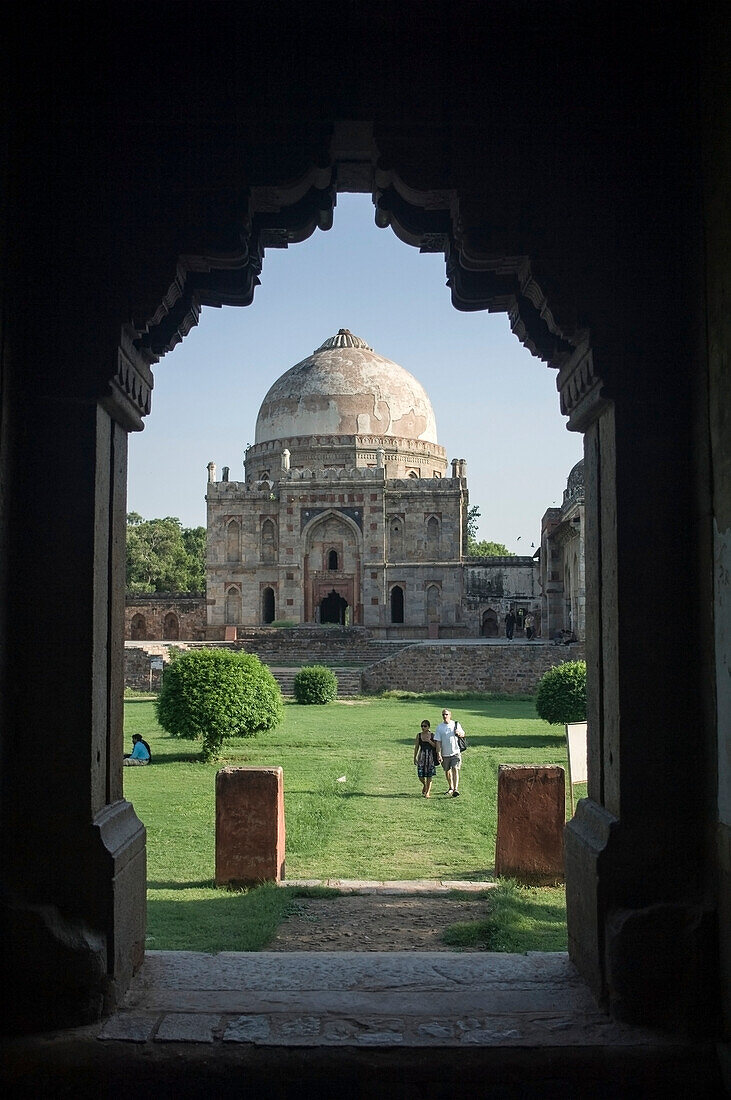 Touristen auf dem Weg vom Bara Gumbad zum Sheesh Gumbad, Lodi Gardens, Delhi. Die Lodi-Gärten sind ein schöner Park in Delhi, der bei indischen Paaren und Familien sehr beliebt ist. Er erstreckt sich über 90 Hektar und beherbergt verschiedene Gräber der Lodi-Dynastie, die über das Land herrschte.